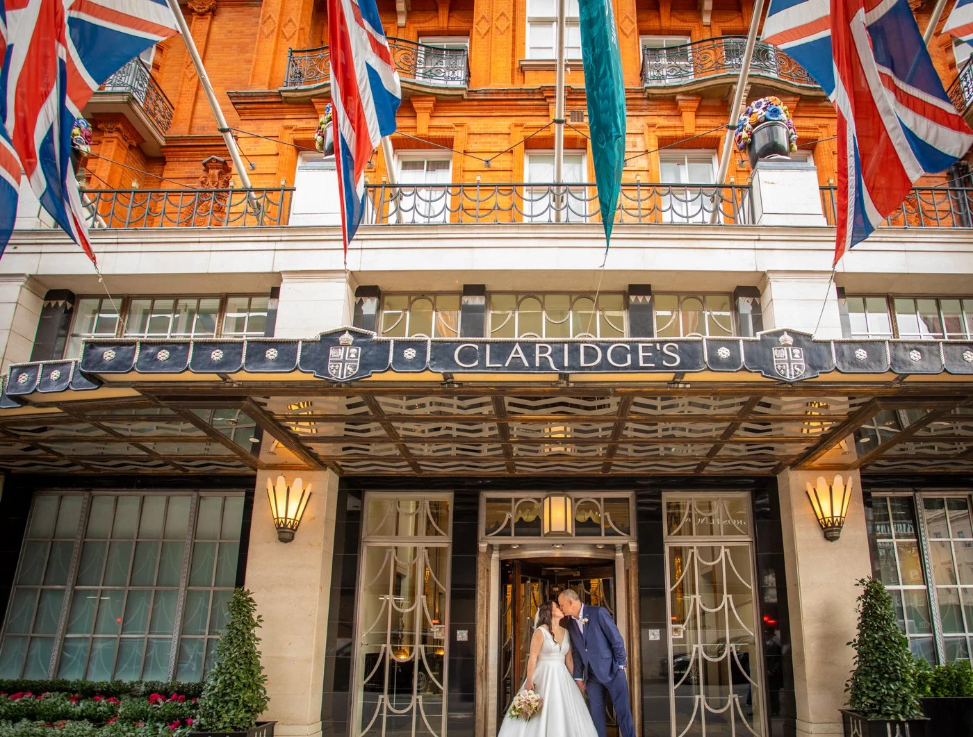 wedding-photograph-claridges-exterior-facade-flags-couple.jpg