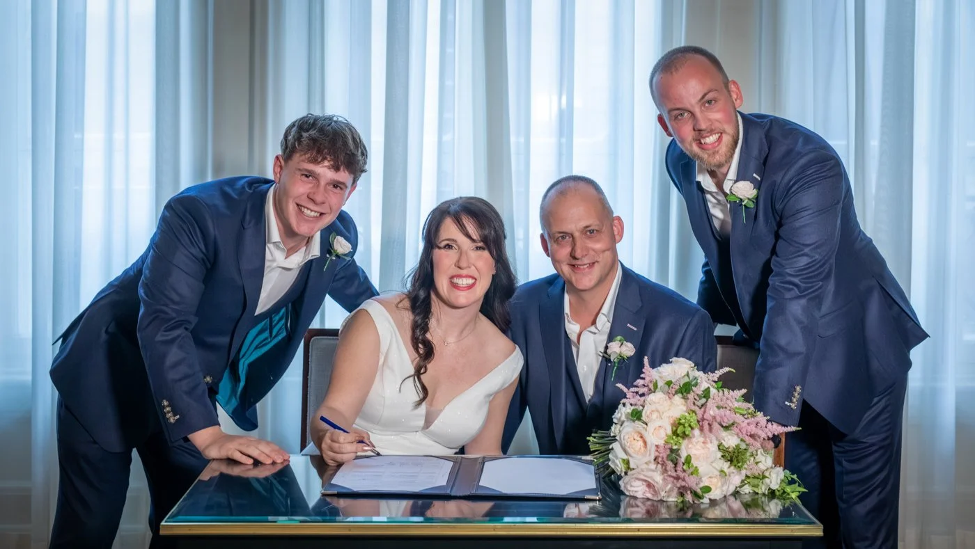 wedding-photograph-claridges-family-signing-register.jpg