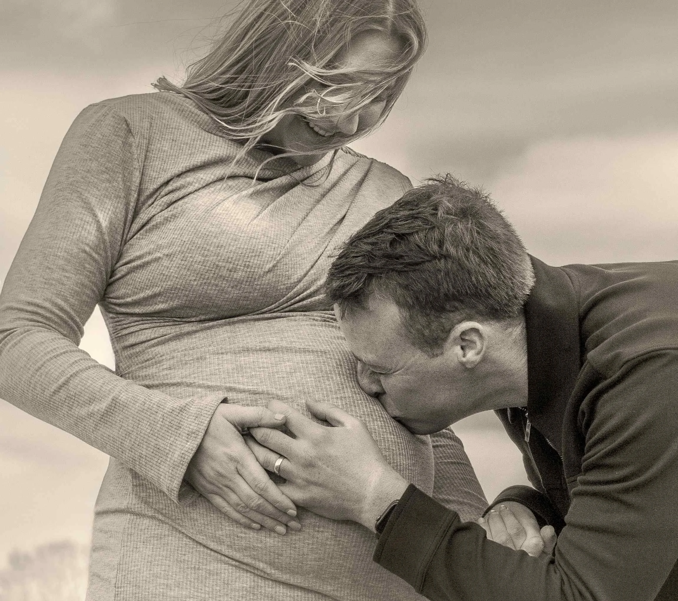 black-and-white-dad-kissing-baby-bump-outdoor-maternity.jpg