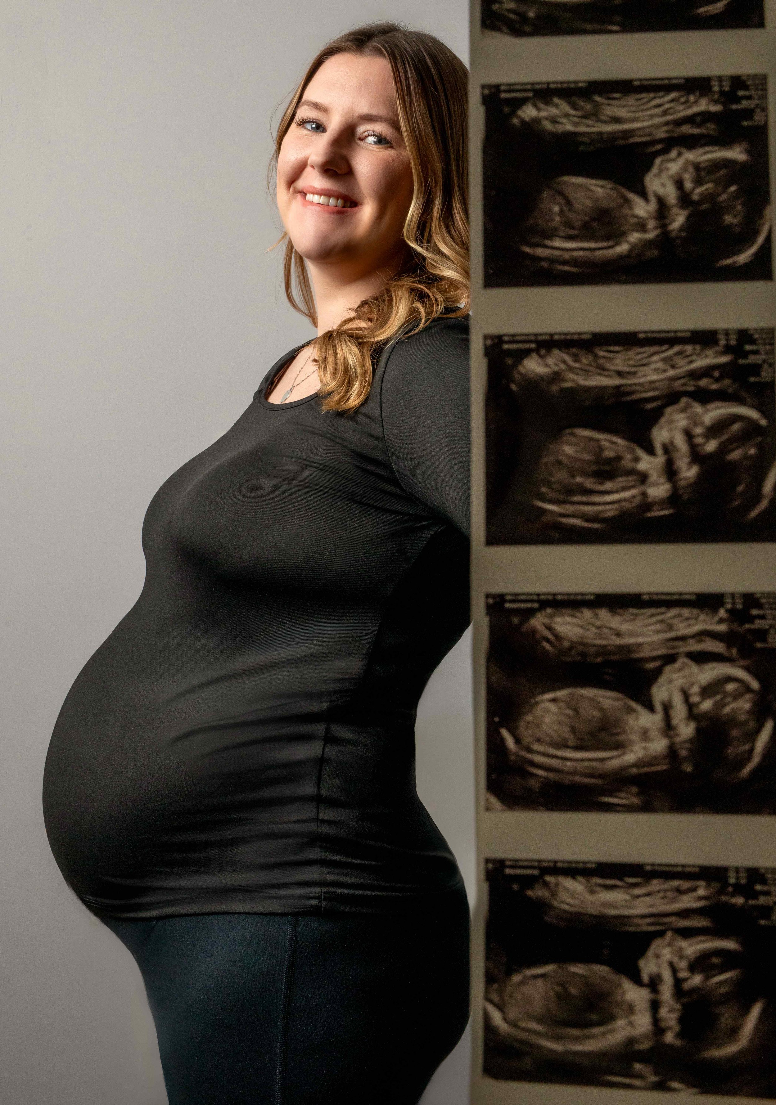 pregnant-woman-studio-portrait-with-baby-scan-photos.jpg