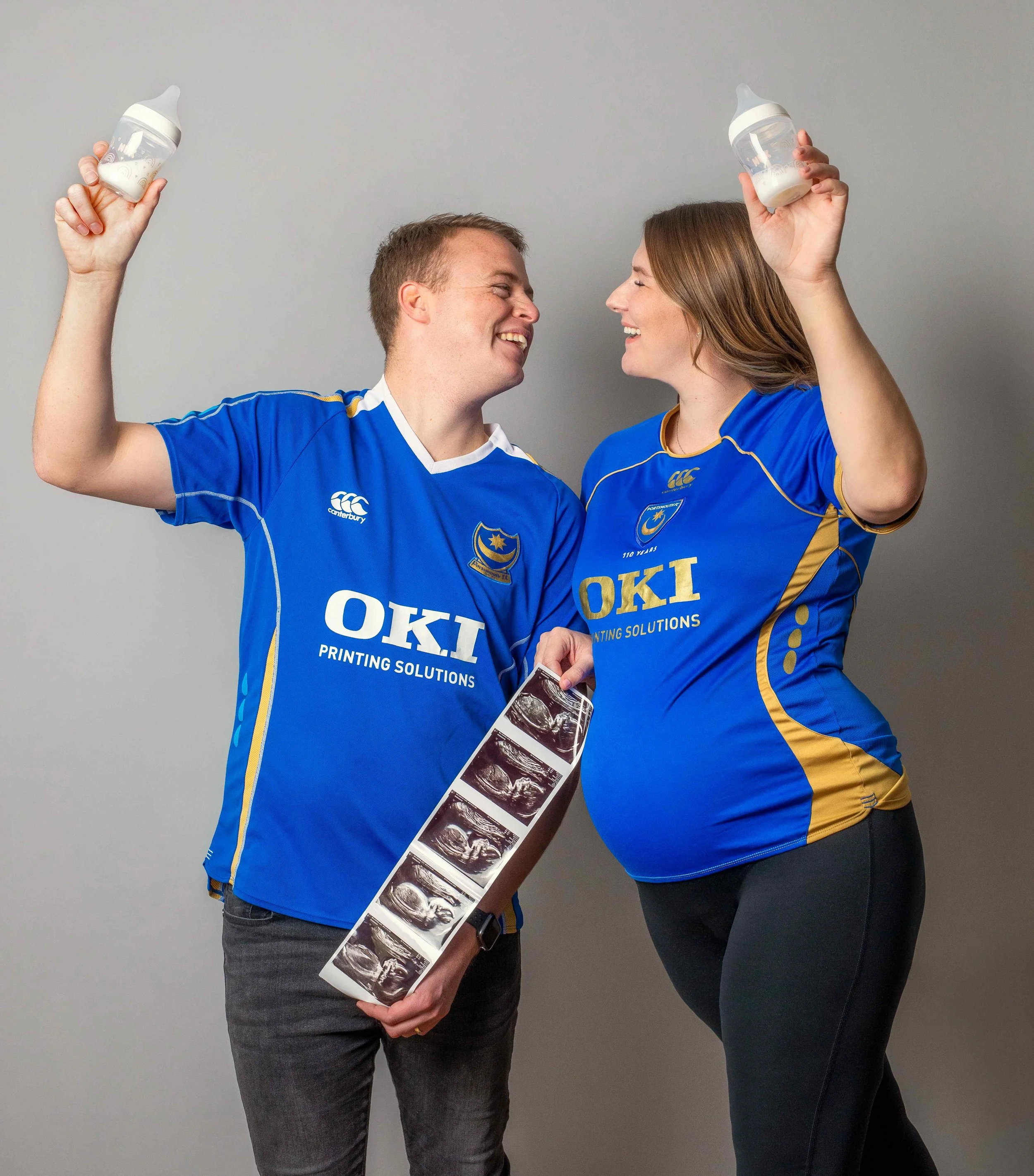 fun-maternity-photo-couple-in-football-shirts-with-baby-bottles.jpg