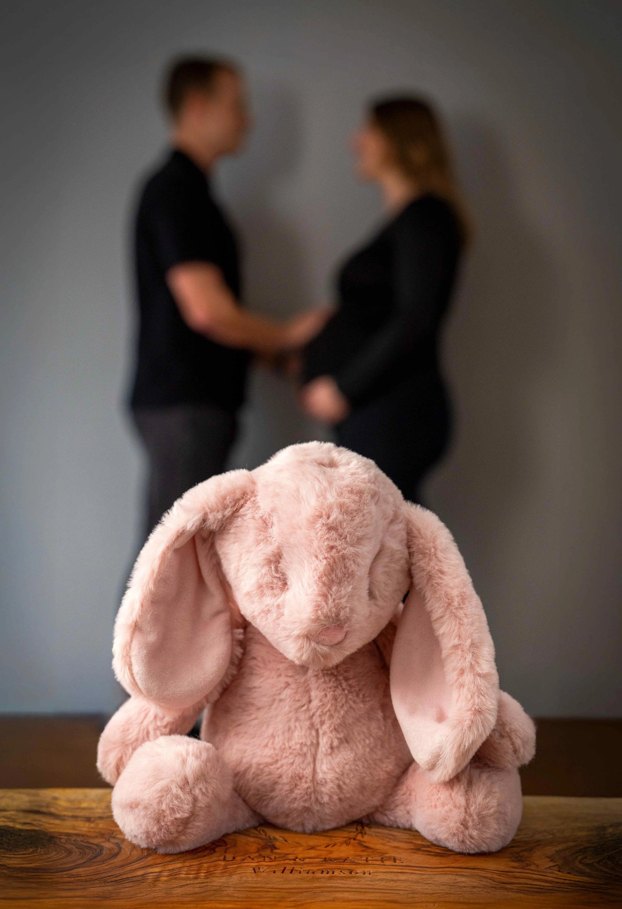maternity-photo-pink-bunny-toy-couple-in-background.jpg