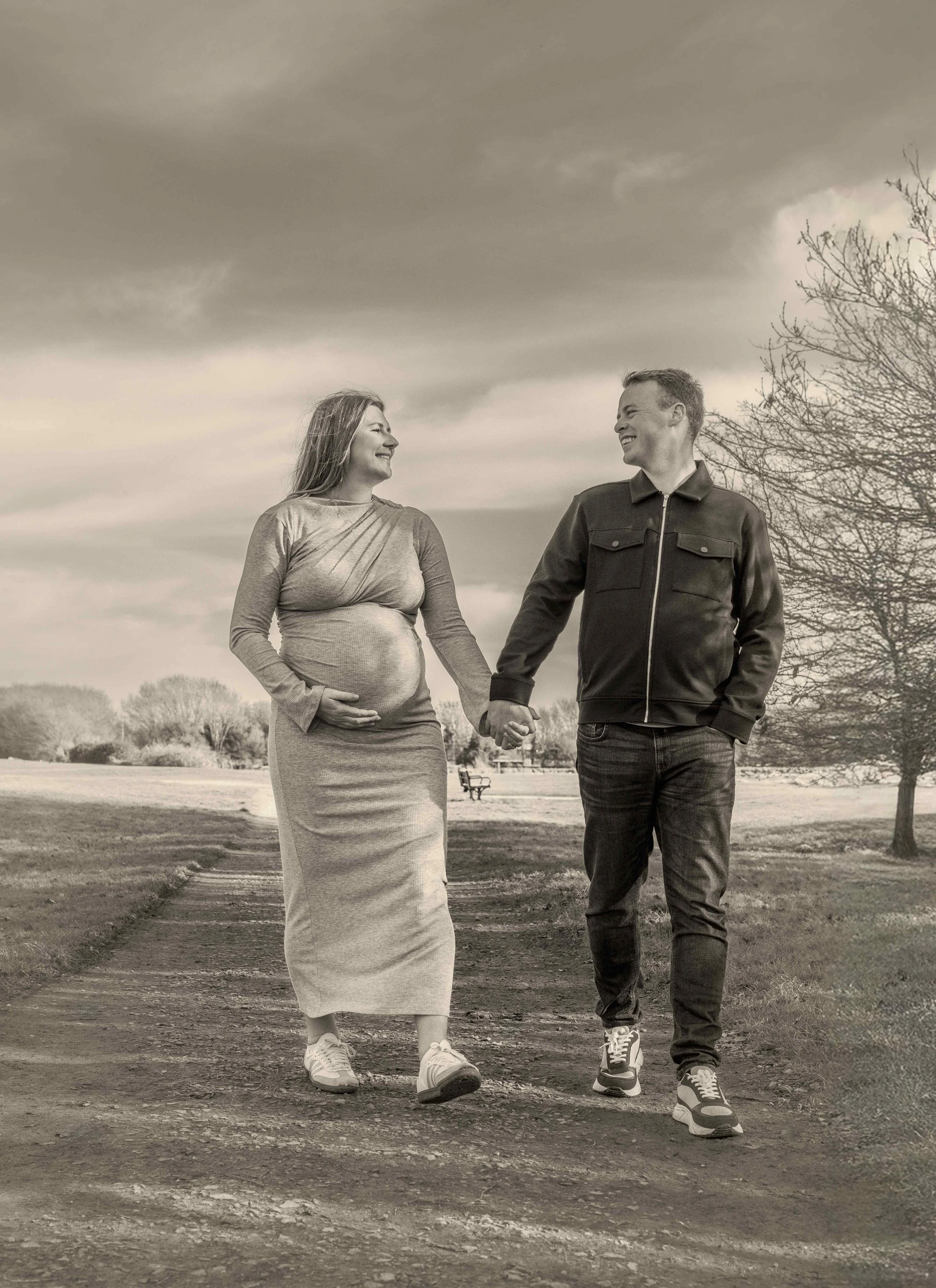 black-and-white-maternity-couple-walking-park-path.jpg