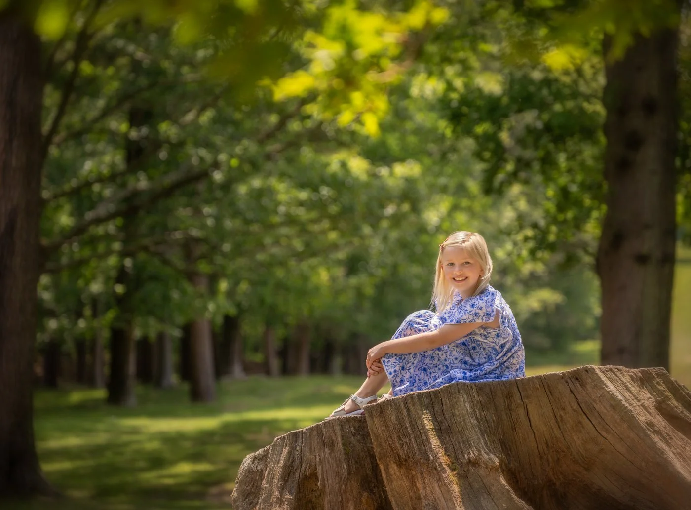 portrait of girl on a big log in countryside