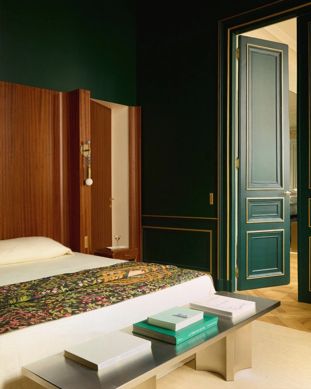 In this bedroom, the bed takes center stage, elevated by a finely sculpted wooden headboard. Our Narrow faceplates, crafted in brass, blend seamlessly with the gold accents of the moldings and architectural details, bringing balance and elegance to t