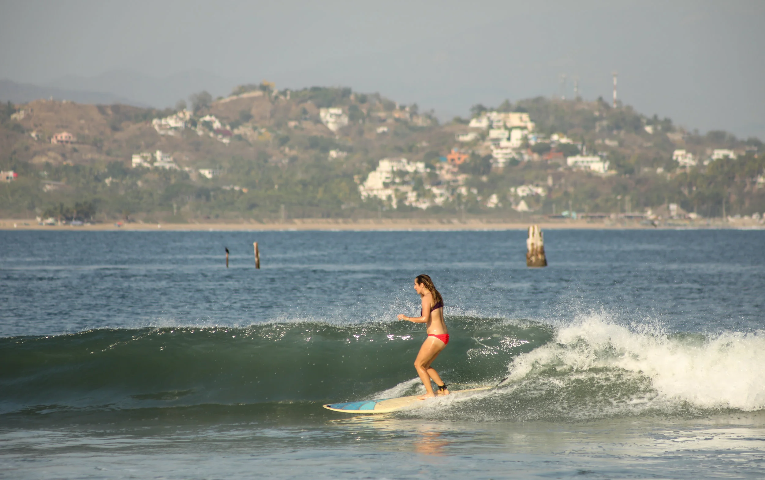 Carly Shredding with the wreck of San Luciano in the background.
