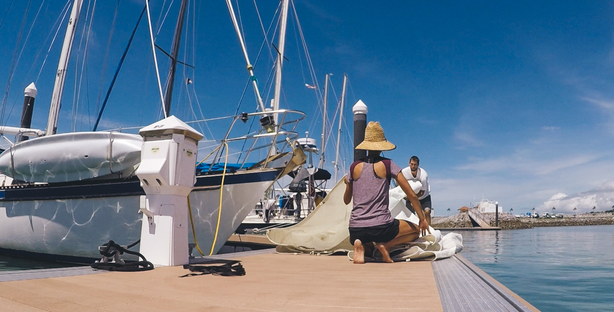 Folding and inspecting our sails before storing them down below.