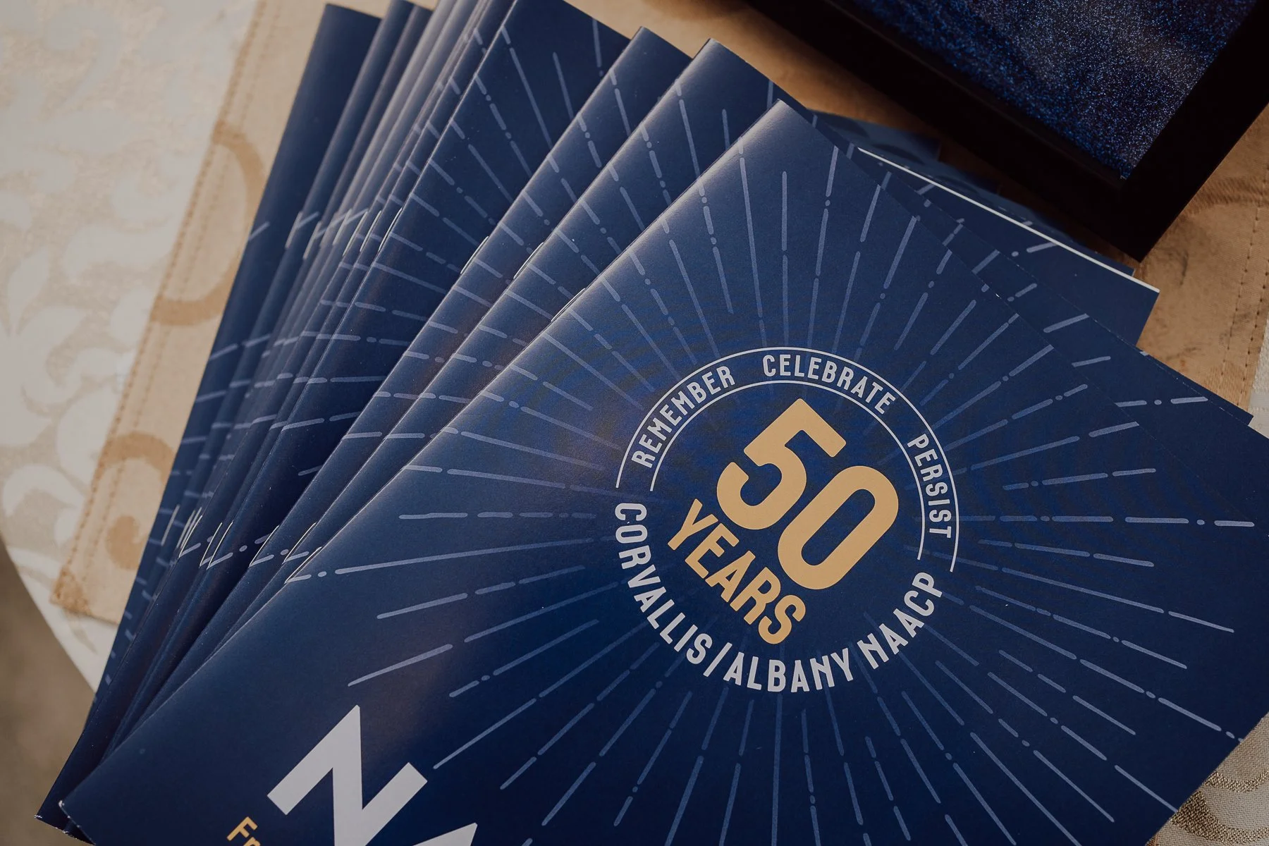 Stack of blue booklets for 50th anniversary of Corvallis/Albany NAACP