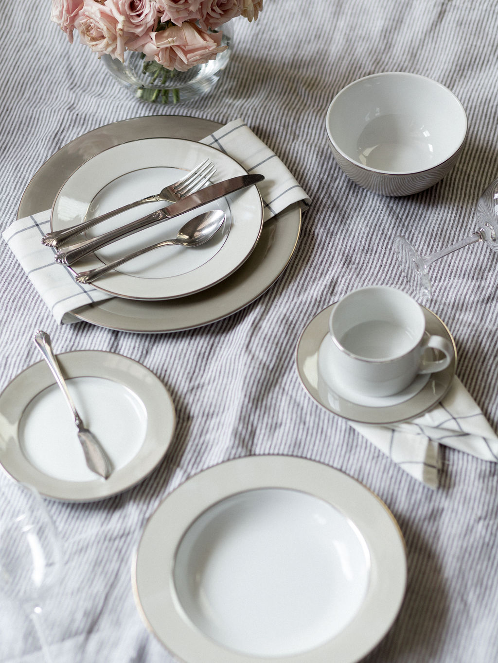 Clockwise: Dinner and Salad Plates with Dinner Fork, Knife, and Spoon; Cereal Bowl (optional); red wine glass; Coffee Cup and Saucer; Salad Bowl; White Wine Glass; Bread Plate with Butter Knife *Dessert Plate, Water Glass, Salad Fork, Soup Spoon, and Teaspoon Not Shown