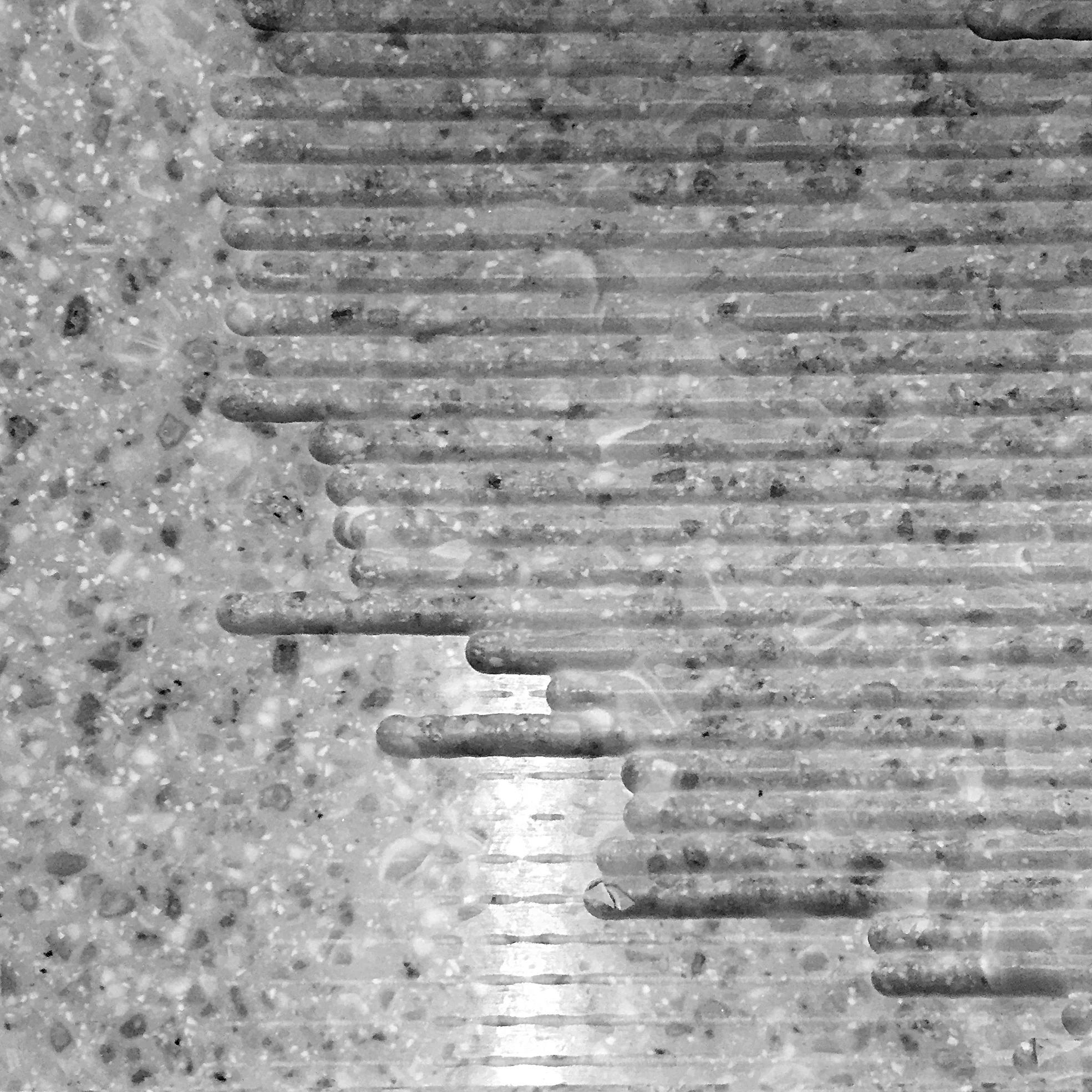 Carving into a surface to create an effect reminiscent of quarry extraction marks.