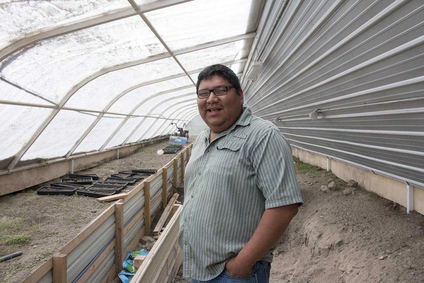 Food Sovereignty Program Coordinator at Thunder Valley, Ernest Weston, stands in a newly built green house on the Pine Ridge Reservation in South Dakota.