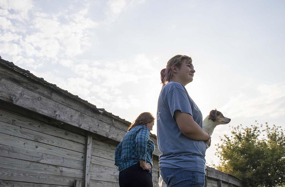   Kristi stands with her oldest daughter, Katie, who holds her dog Scooter.  