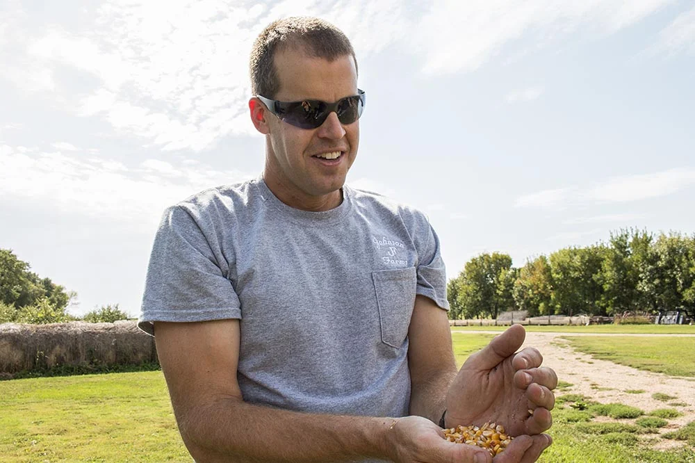   Aaron Johnson holds a handful of corn at his farm in Madison, South Dakota, Johnson Organic Farm.  