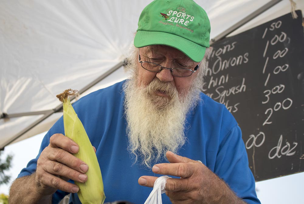 Luc bags corn for a customer at Landon’s Greenhouse Saturday Farmers Market in Sheridan, Wyoming.