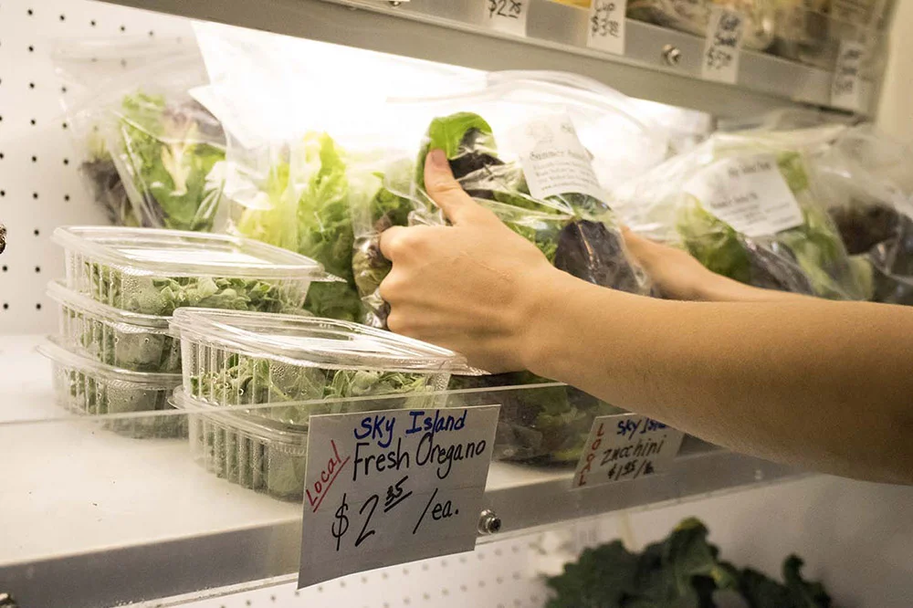 A store employee stocks Sky Island products.