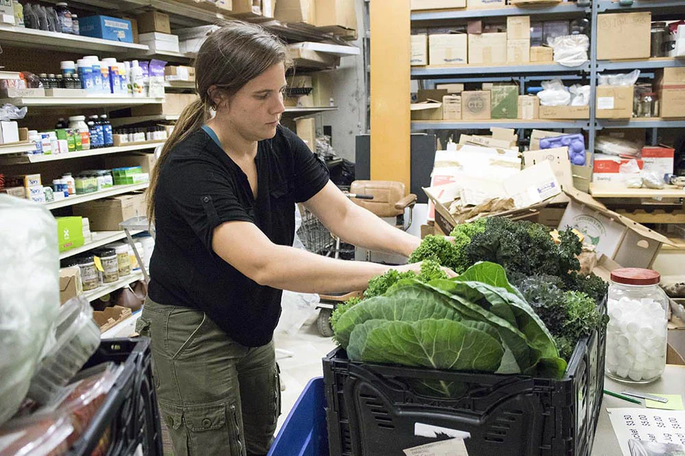   Kate sorts greens at a local grocery store.  