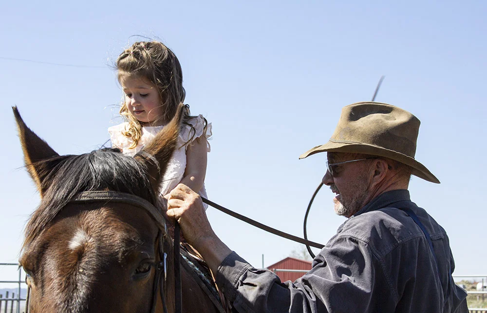 Stevie (left) on horseback next to her grandfather Steve.