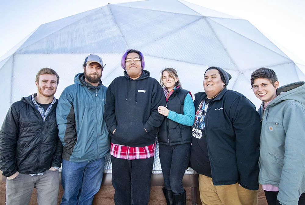 From left to right, the Sicangu Food Sovereignty Initiative Staff, Aaron Mandell, Mike Prate, Edwin Her Many Horses, Rachel Kent, Matt Wilson and Hollis Vanderlinden in front of a greenhouse at the Keya Wakpala Garden, in South Central South Dakota, on the Rosebud Reservation.