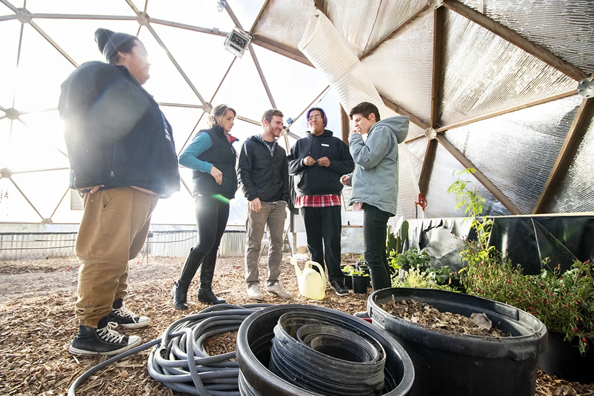 The Sicangu Food Sovereignty Initiative Staff, Matt Wilson, Rachel Kent, Aaron Mandell, Edwin Her Many Horses, and Hollis Vanderlinden in the greenhouse at the Keya Wakpala Garden, in South Central South Dakota, on the Rosebud Reservation.