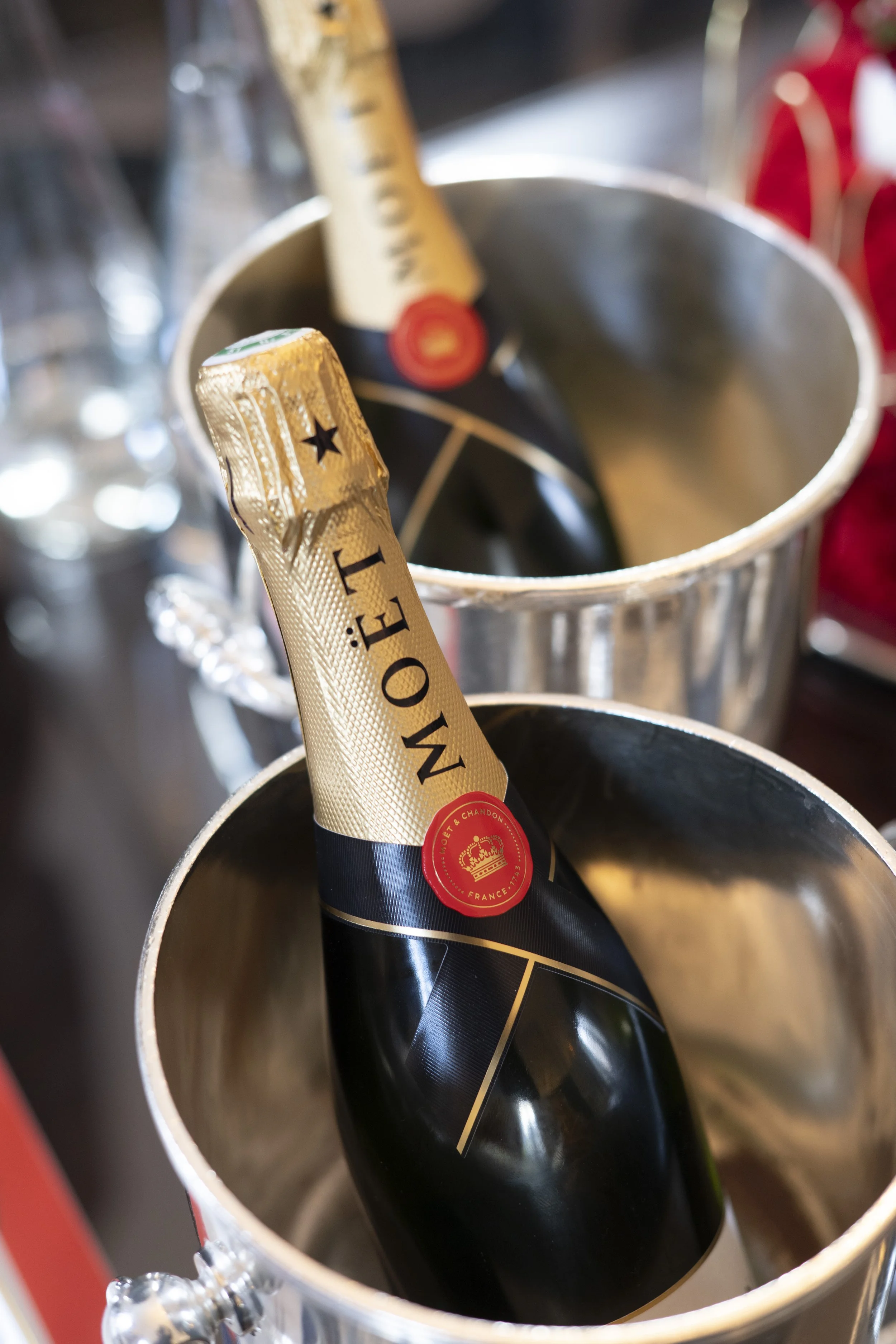 A bottle of Moët & Chandon champagne inside an ice bucket, with another bottle in the background.