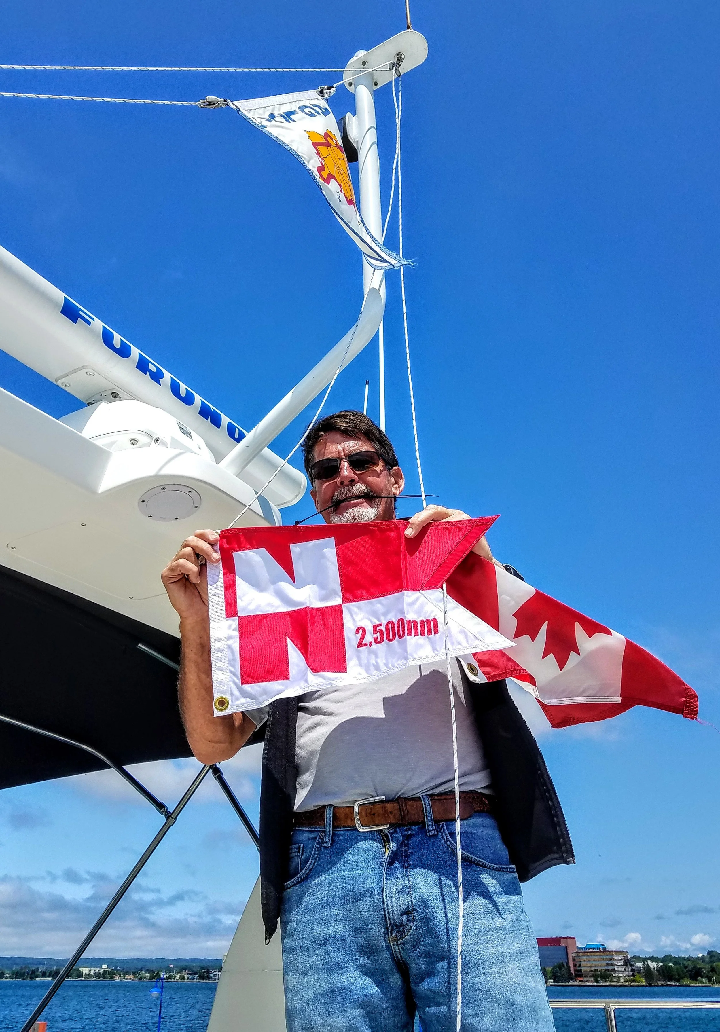 Larry replaced our Canadian courtesy flag with our Nordhavn 2,500 nautical mile pennant flag after re-entering the U.S. at Sault Ste. Marie, MI in the George Kemp marina.