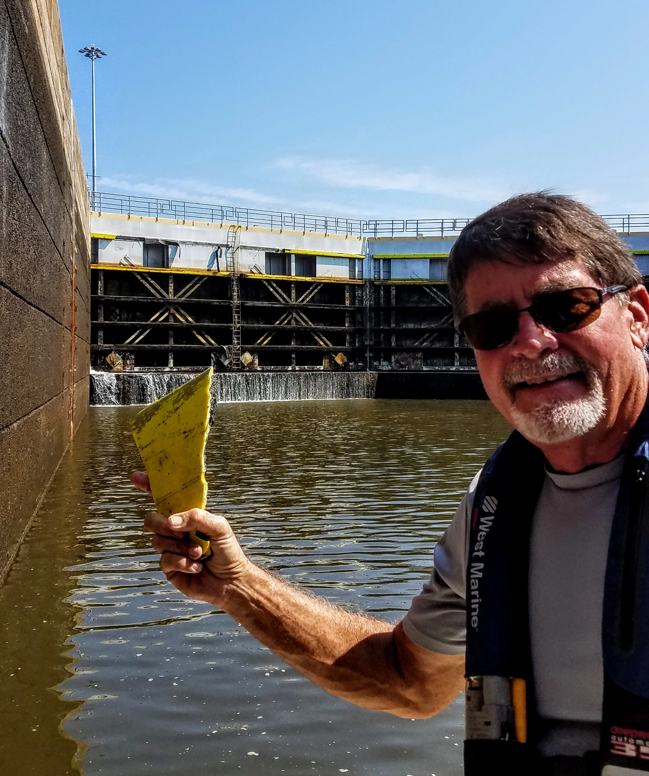 Larry holds up just a small portion of the fender that had been ripped from the lock door (behind him in the background). Most pieces were five to ten feet long.