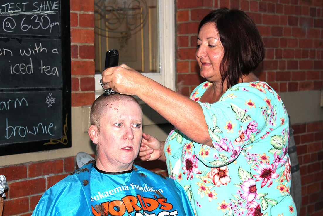 Outside the Empire Hotel for the 21st World’s Greatest Shave, hairdresser Liz Walker wields her clippers on Mole Creek cave guide Angela Enright. Photo | Hayley Manning