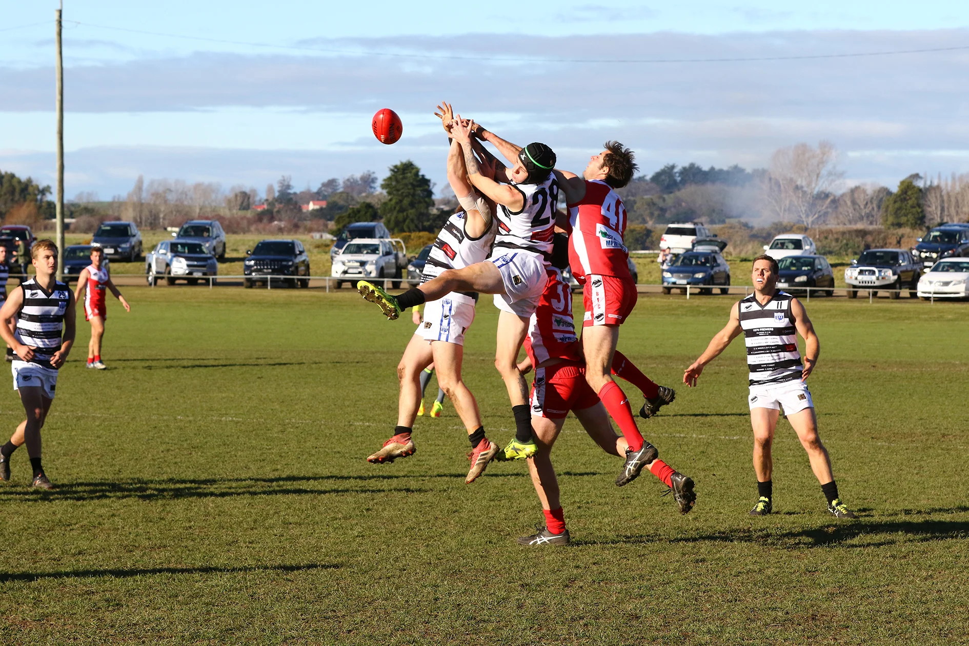 Playing in his 312th game, Kangaroo's Captain Brad Crowden looks on as Bracknell and Deloraine players reach for the ball. Photo by Mike Moores