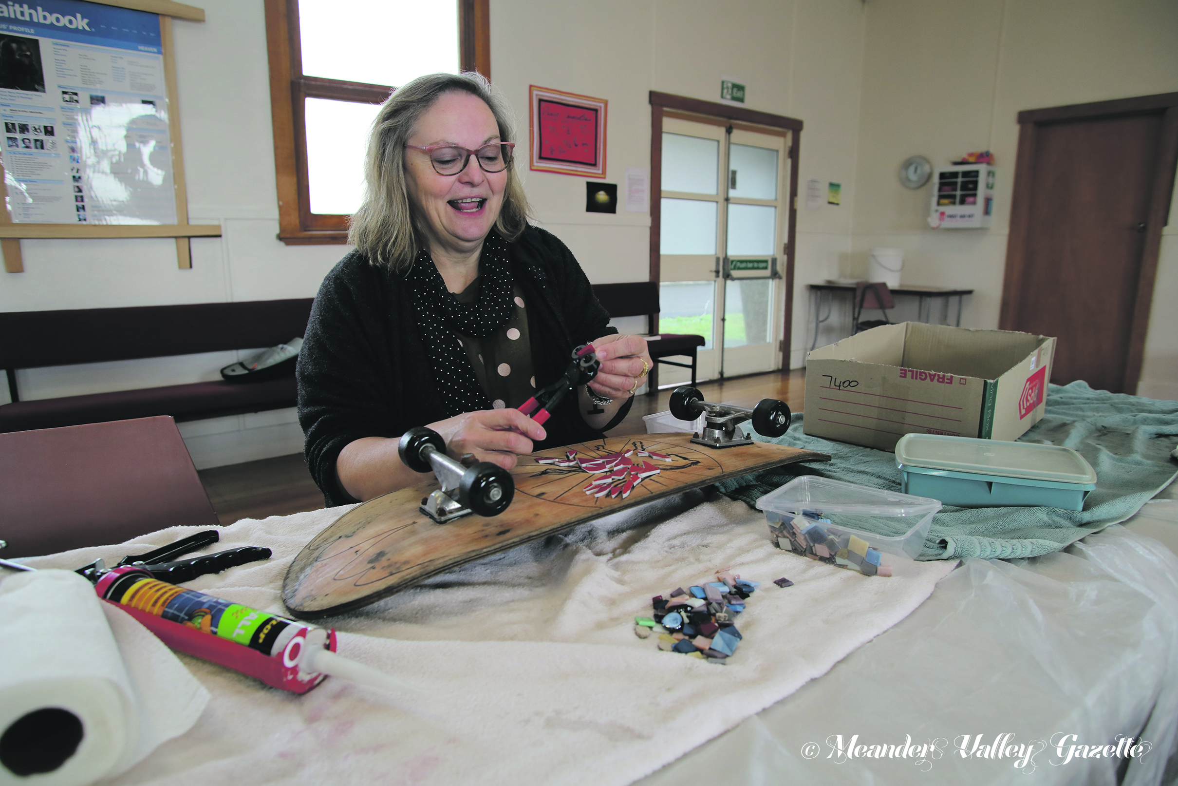 MVU3A member Susanne Puccetti works some of her mosaic magic on an old skateboard. Photo by Mike Moores