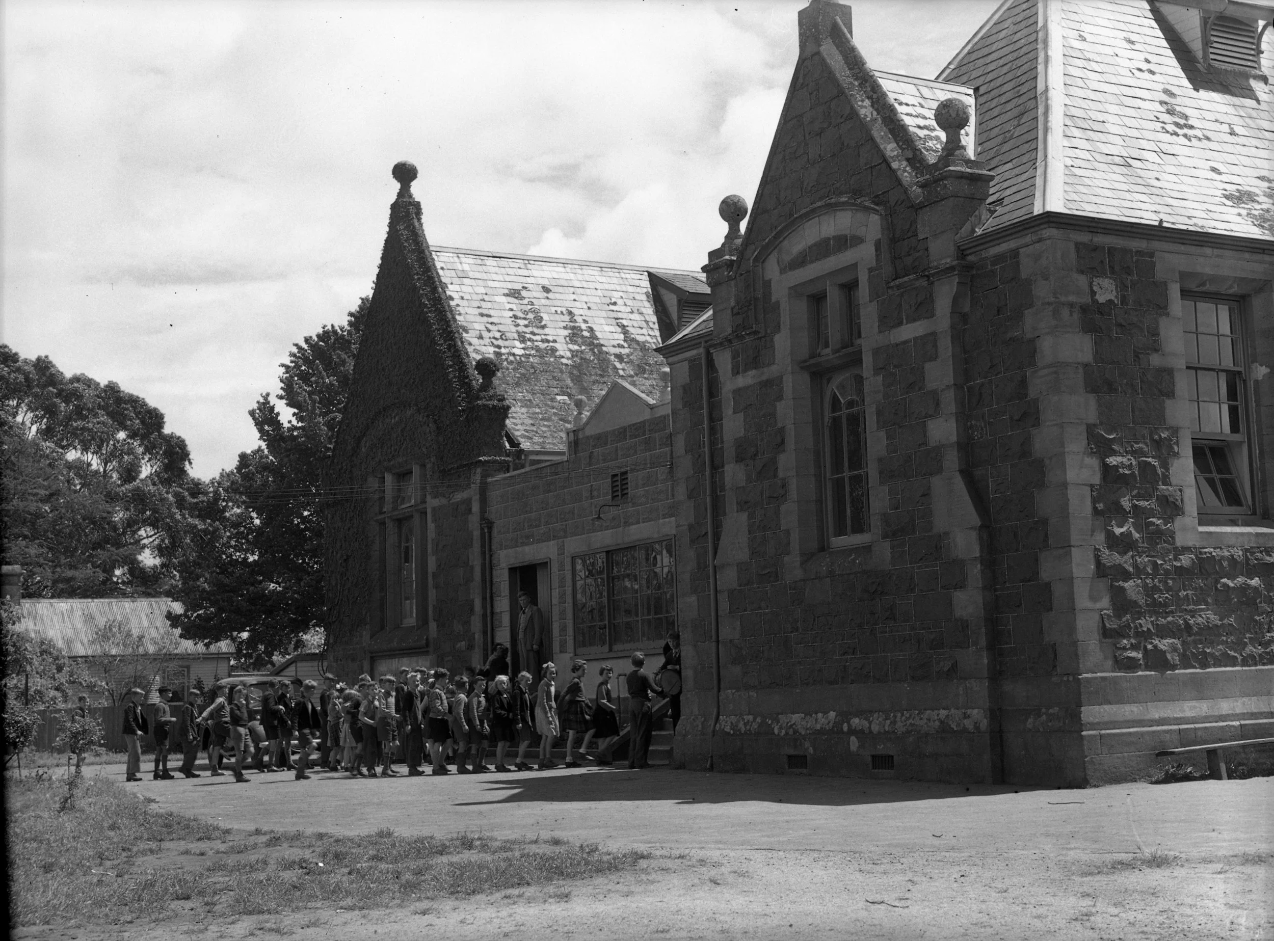 Westbury children line up to go inside the impressive bluestone building that once housed Westbury State School. Tasmanian archives: Westbury State School (1953). Photo supplied