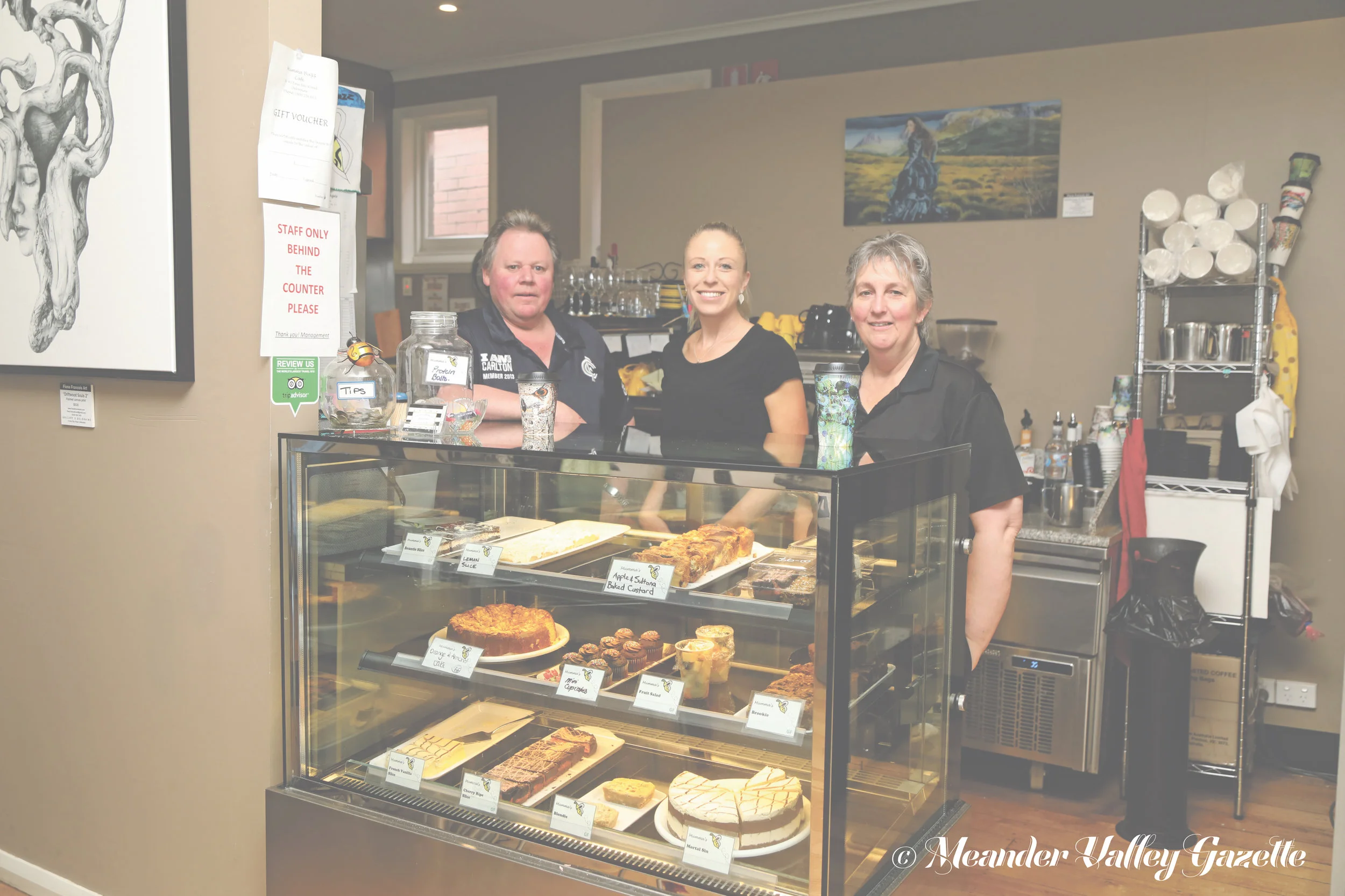 Photo by Mike Moores Buffy, Natalie Woolford and Carolyn Bussey behind their fabulous cake cabinet at Mumma Buzz Café.