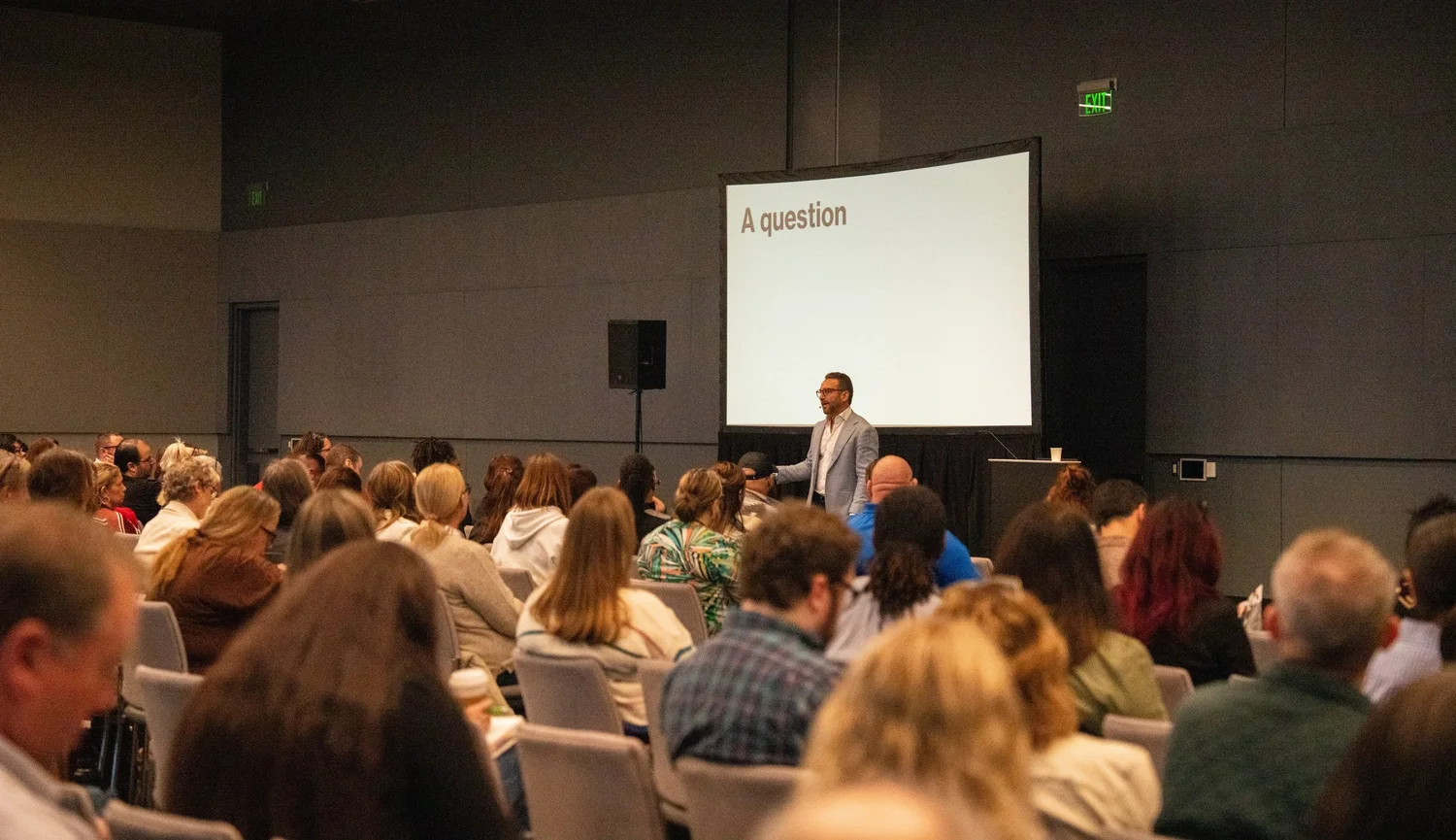 Dr. Adi Jaffe working with a live audience, standing among the rows