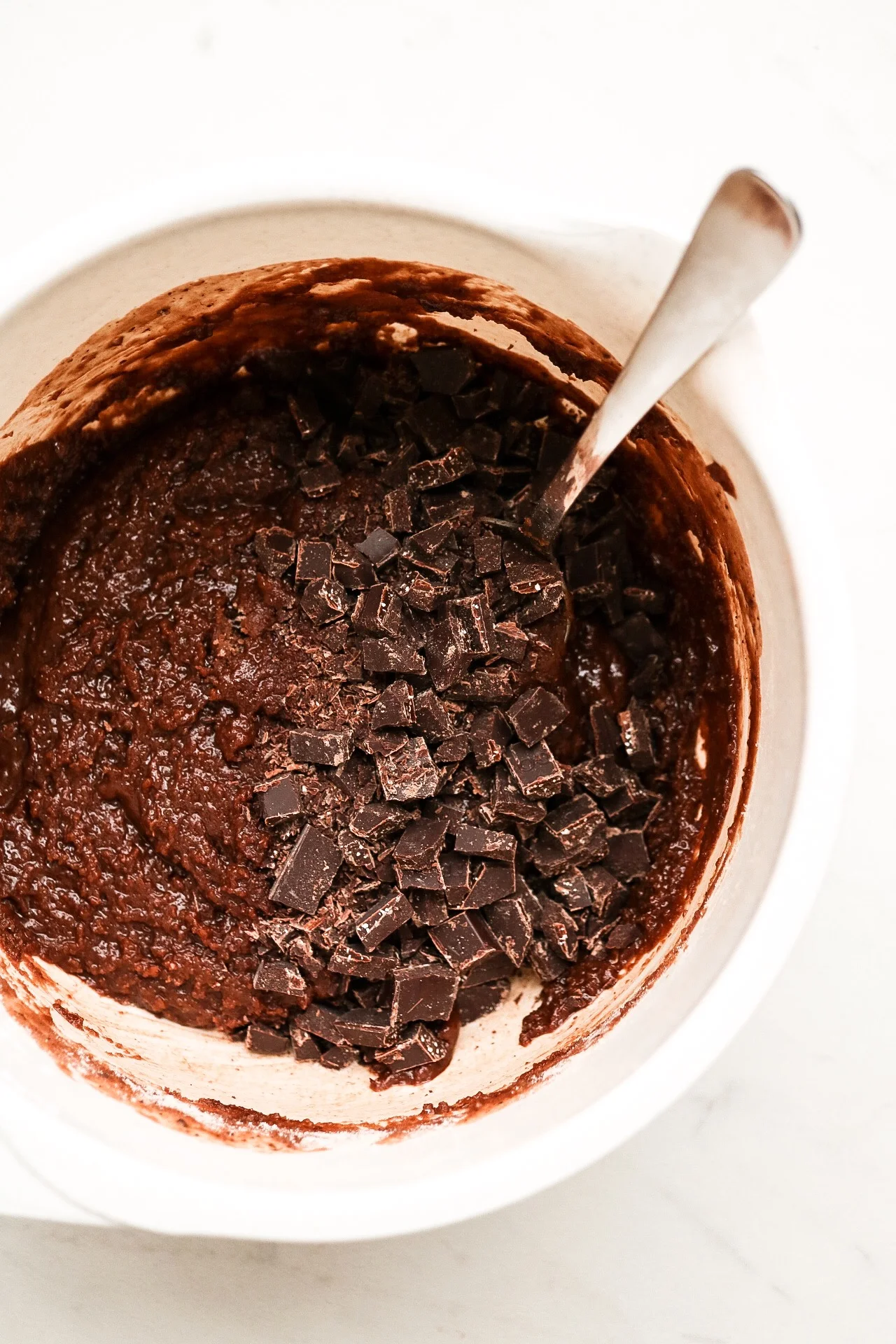 Fold in your chopped chocolate into the batter and mix! Then, just pop em into the oven for about 15 minutes.