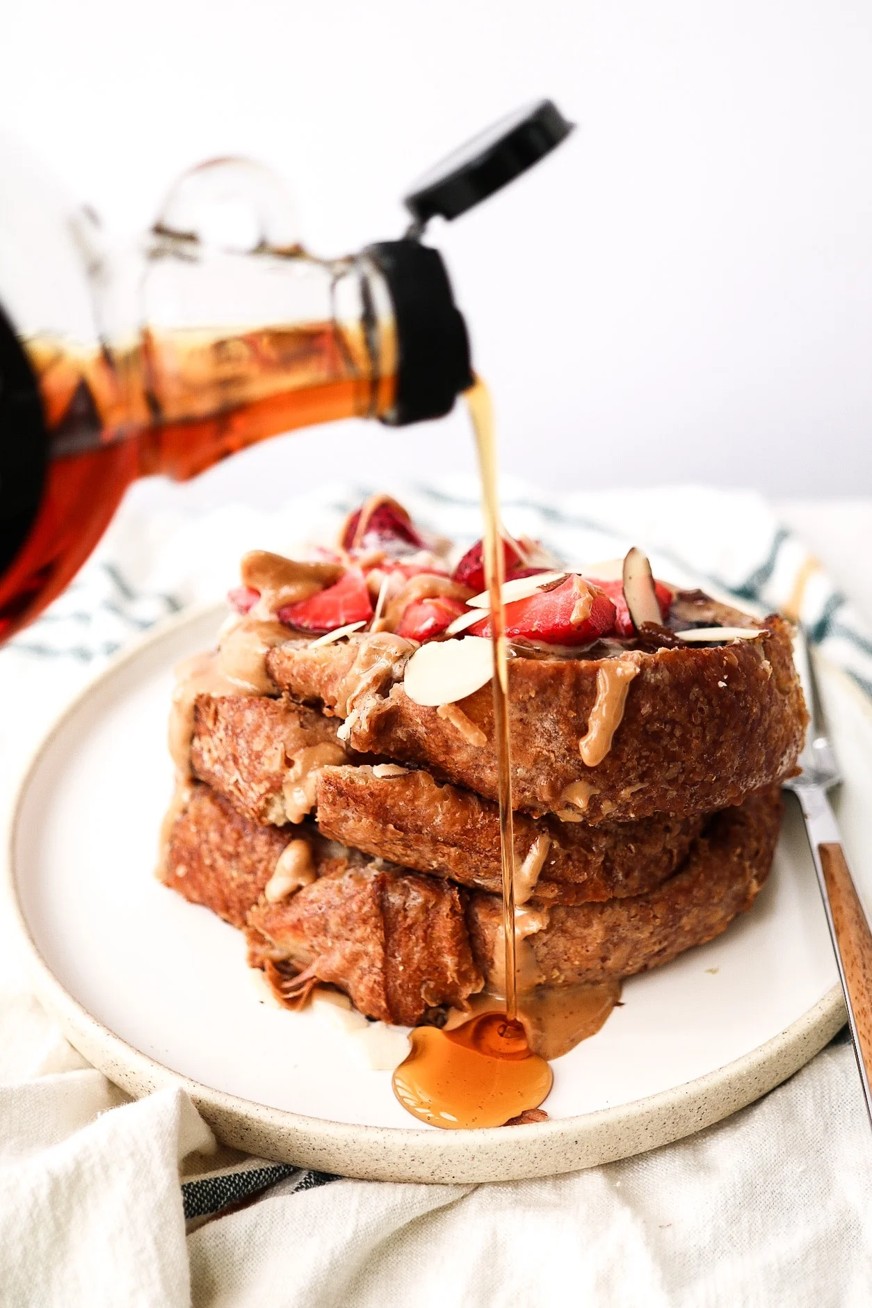 Then, just add your toppings! I drizzled mine with peanut butter, vegan yogurt, strawberries, sliced almonds, and a generous drip of maple syrup.