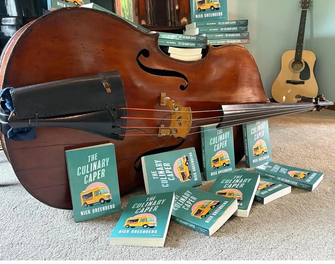 Cello on the floor with copies of book