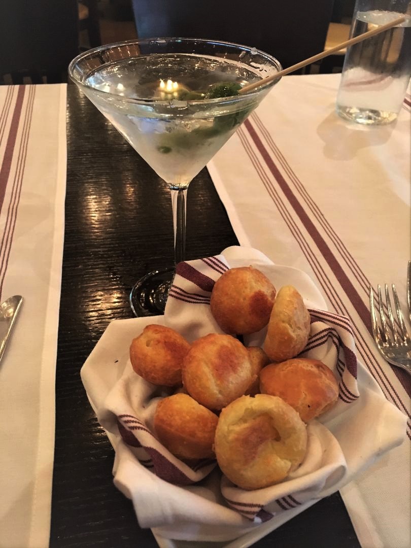 A cold martini and a basket of gruyere cheese puffs
