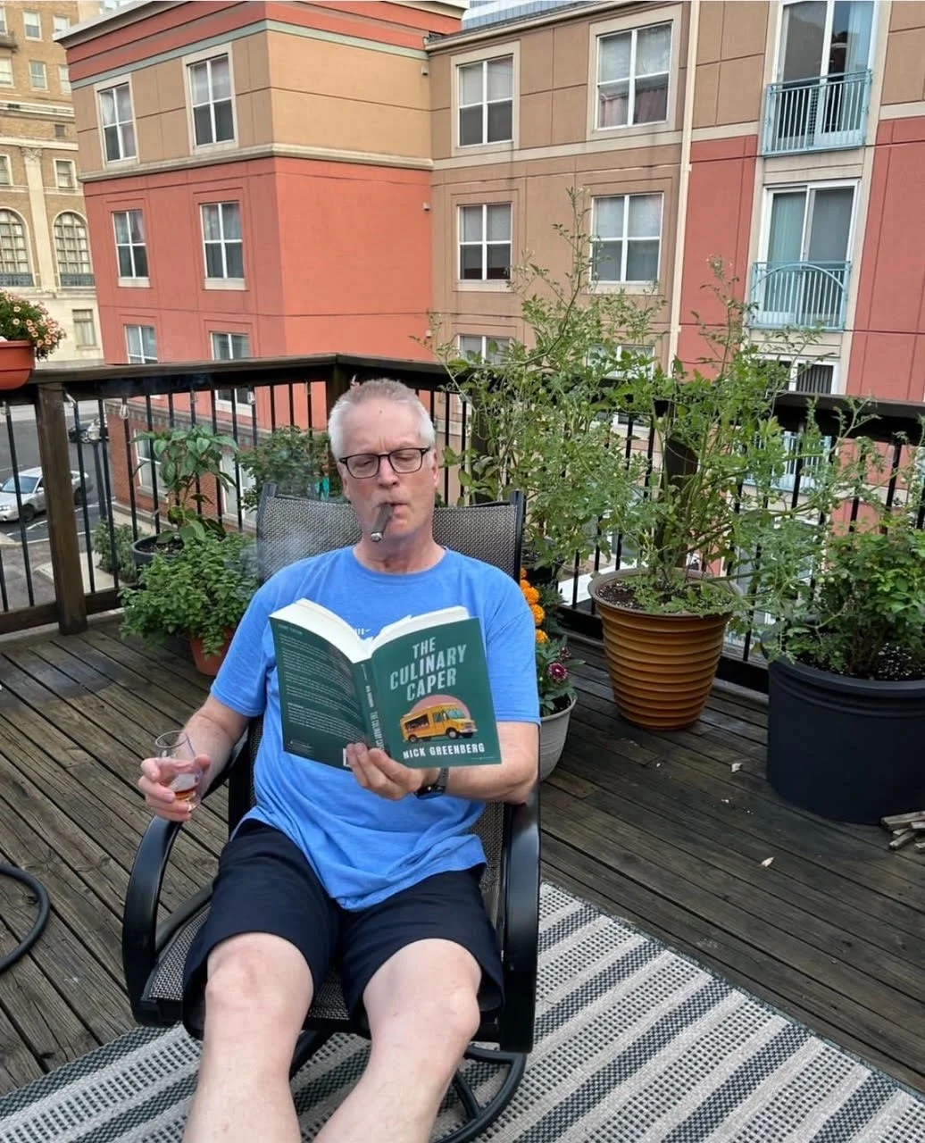 A fan enjoys the book with a little cigar and drink in hand
