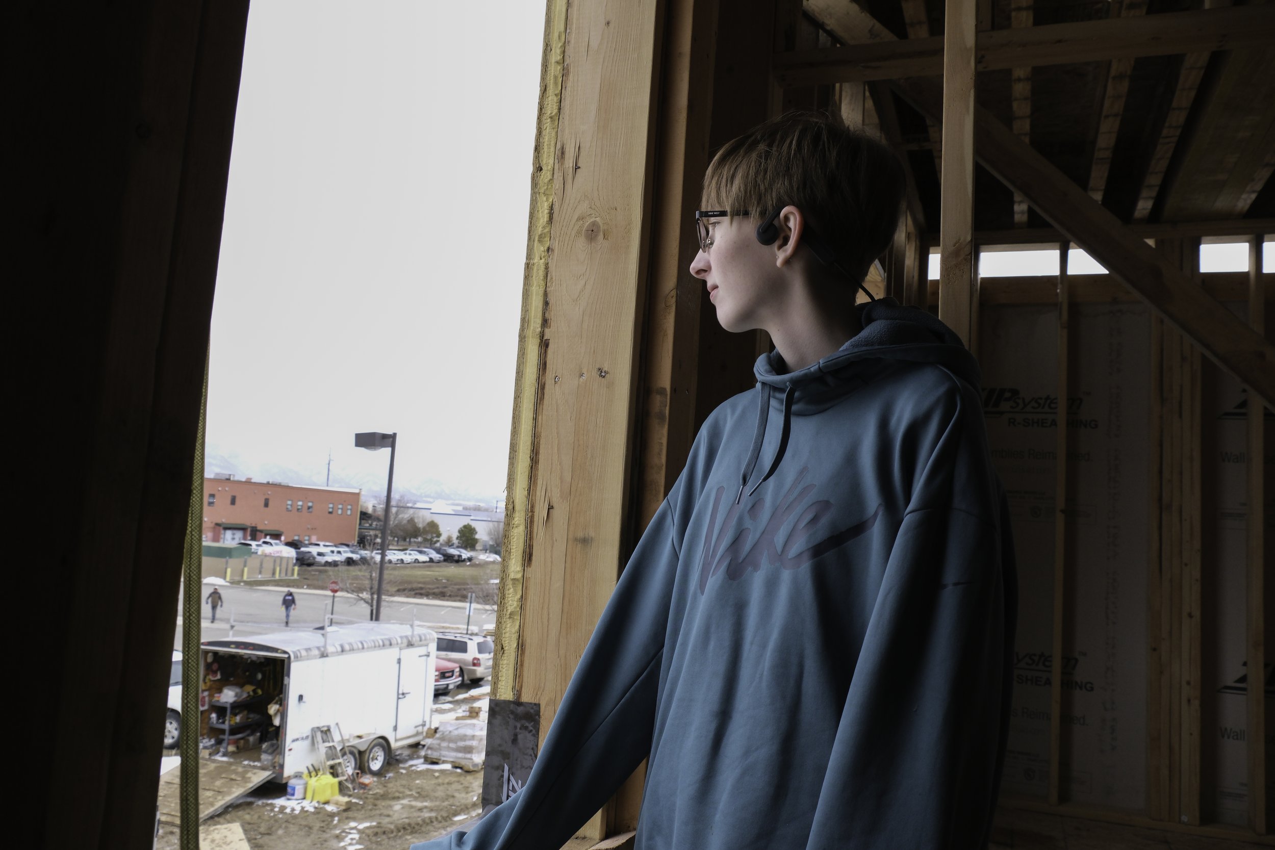 Teenager looks out window of her future home, shot for High Country News