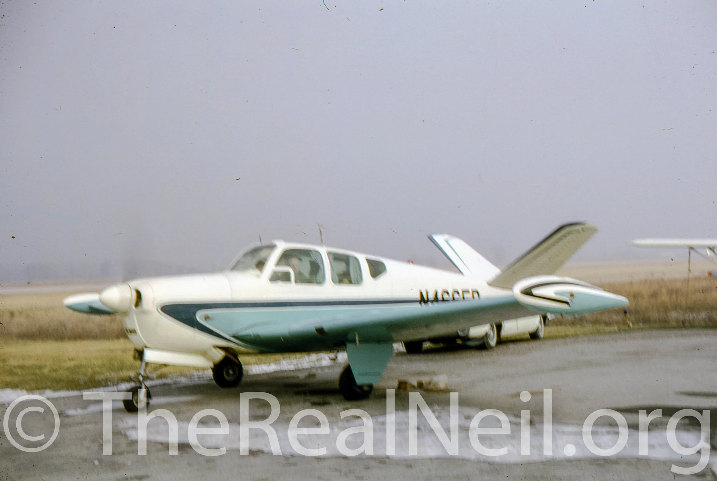 Neil readies airplane before take off. Early 1960s.