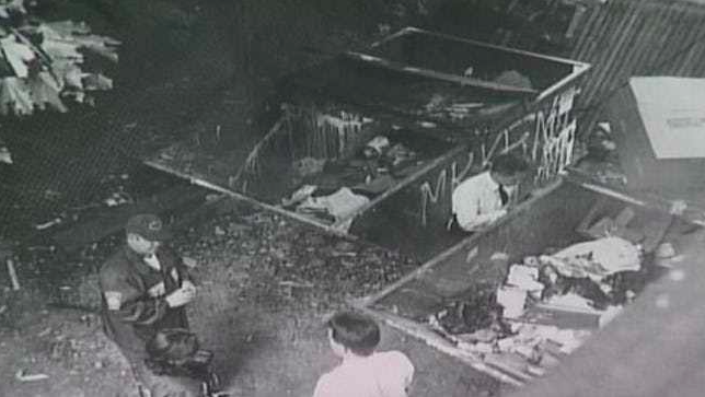 Investigators at the dumpster in which half of Karina’s body was found.