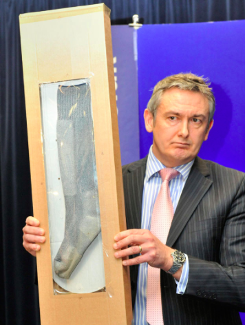Detective Chief Inspector Phil Jones holds up a sock similar to the missing one