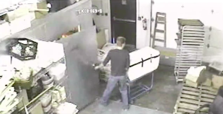 A still from the surveillance footage of Travis wheeling the cooler into the bakery’s walk-in freezer from his van. You can watch the 17-second clip here.