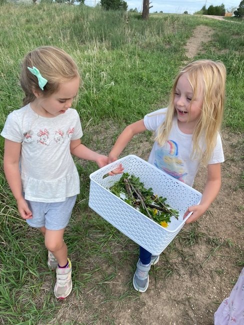 kids helping each other carry a box at preschool