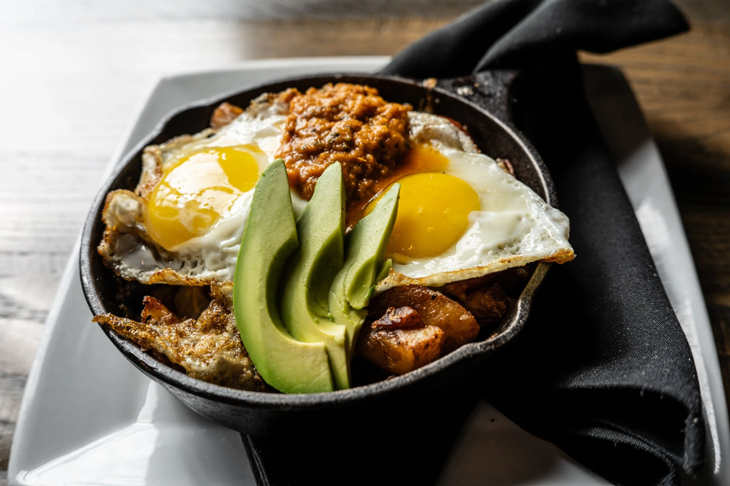 herb-roasted potatoes, onions, peppers, andouille sausage, cheddar jack cheese, sunny-side-up eggs, roasted tomato salsa, avocado 