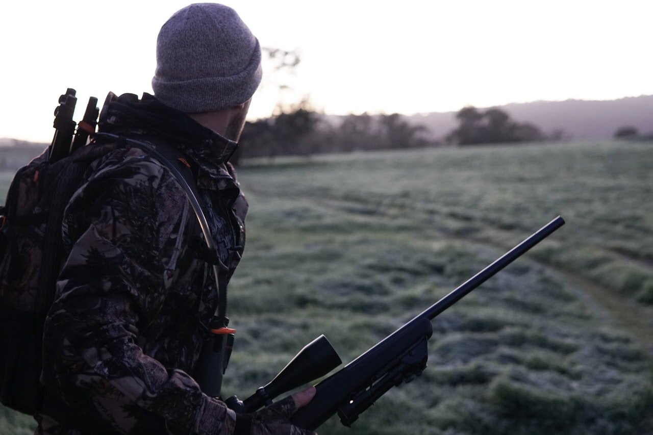 man-wearing-gray-and-black-camouflage-jacket-holding-rifle-2954926.jpg