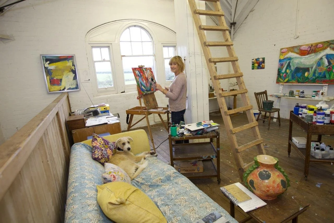 Artist Catriona Stewart painting in her art gallery in North Yorkshire