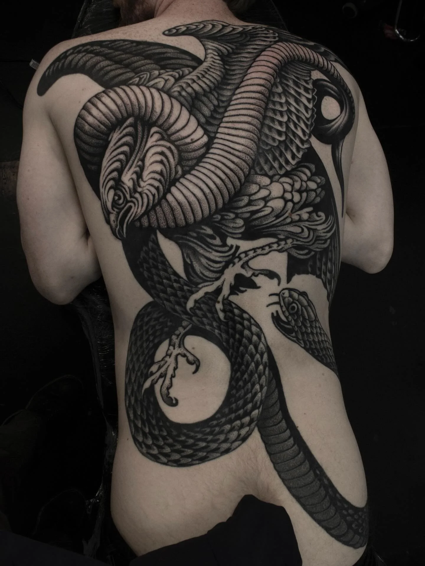 Snake and eagle blackwork back tattoo at Red Point Tattoo Islington