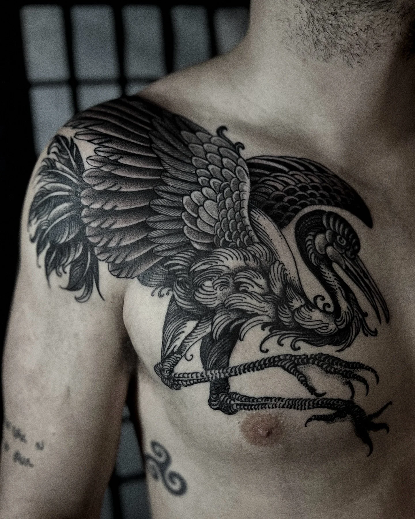 Crane blackwork chest tattoo at Red Point Tattoo London