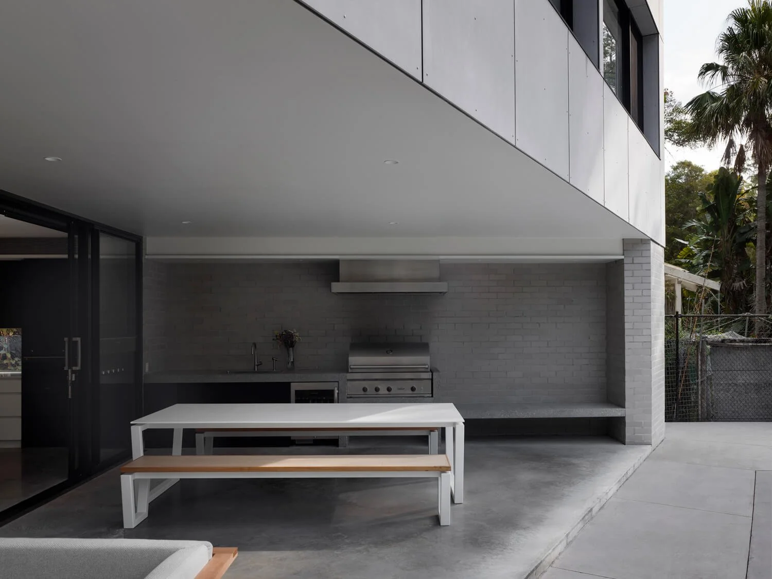 Flood-resilient outdoor entertaining with concrete raft slab and suspended concrete BBQ bench above flood planning level, Pearl Beach architect