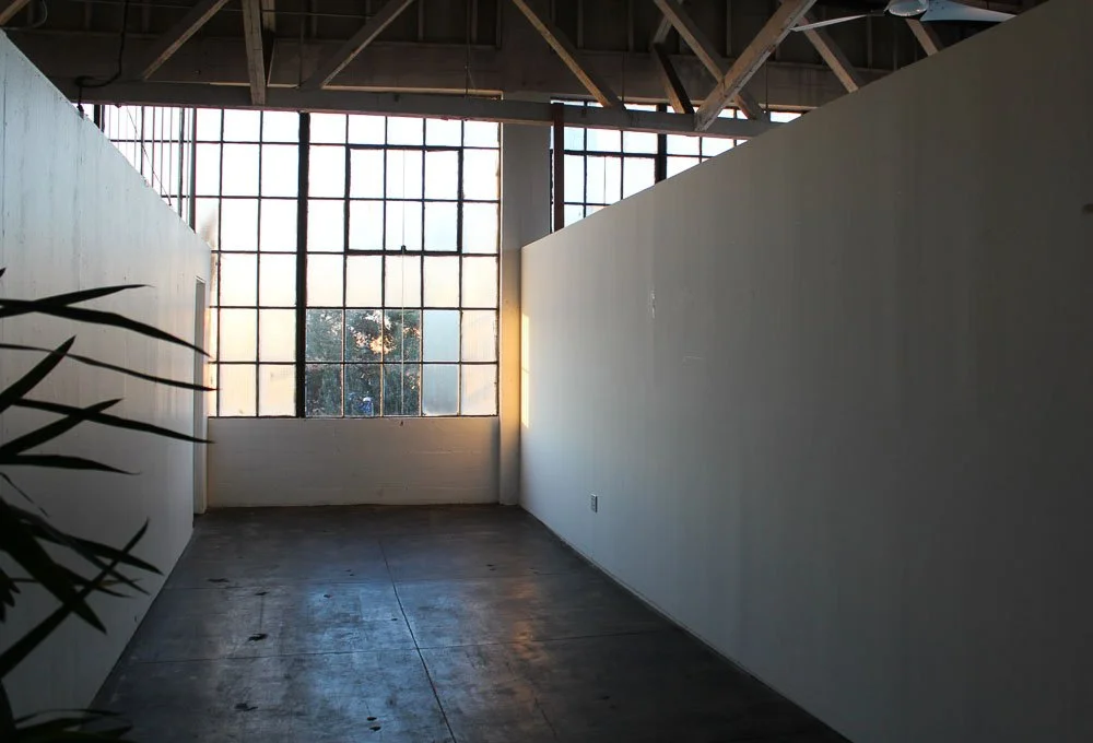 Empty room with large industrial-style window and wood ceiling